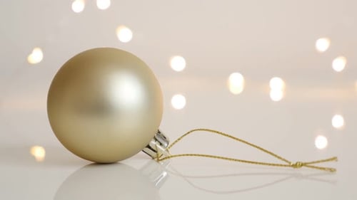 Elegant Gold Christmas Ornament on Reflective Surface