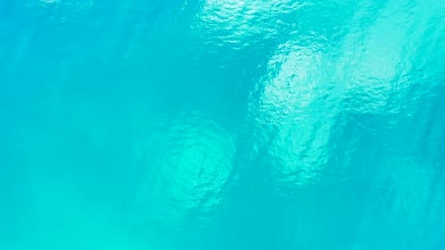 Breiter Luftinselblick auf einen sommerlichen weißen Paradies-Sandstrand und einen türkisfarbenen Wasserhintergrund