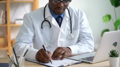 Doctor Writes Medical Report in Hospital Office Spbas