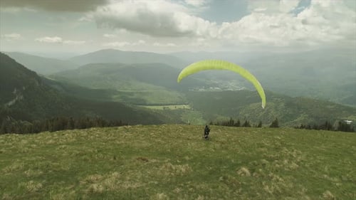 Mann mit einem Gleitschirm von einer Drohne verfolgt