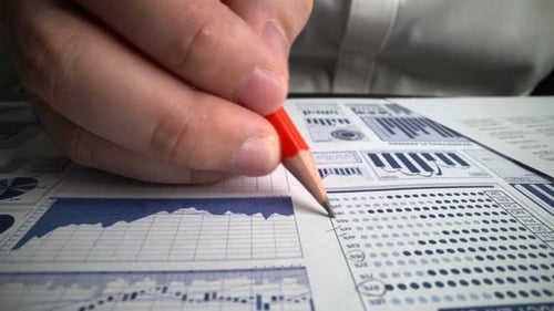 Accountant analyzing business marketing data on paper dashboard at office table.