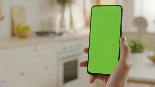 Point of View of Woman Holding Chroma Key Green Screen Smartphone Watching Content Without Touching