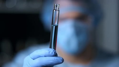 Medical Professional Holding Test Tube in Hospital Lab