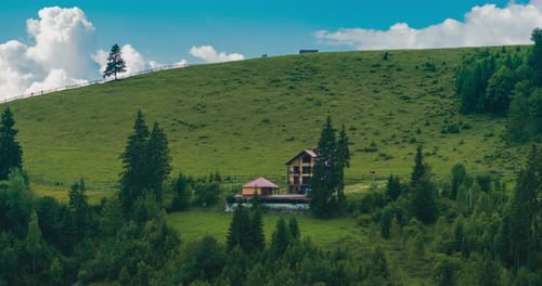 Time lapse. Vacation home in rural area on the hill, clouds passing over the mountain range