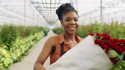 Woman Holding Roses Bouquet in Greenhouse Smiling