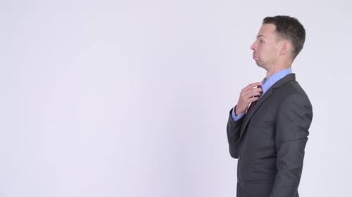 Profile View of Businessman Fixing His Tie