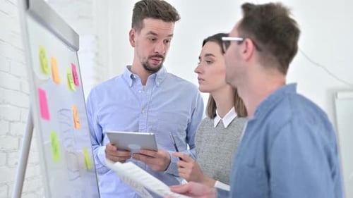 Team Brainstorming Ideas at Whiteboard in Office