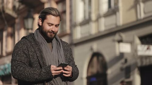 Man Using Phone on City Street
