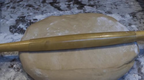 Dough Being Rolled Out on Counter