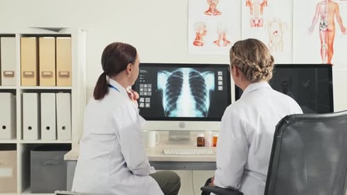 Doctors Analyzing X-Ray Together in Office