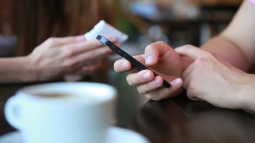 Young Married Couple Uses Smartphones in the Cafe