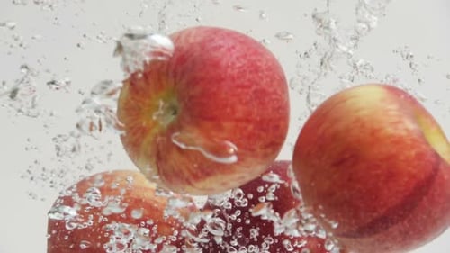 Peaches Splashing into Water with Bubbles