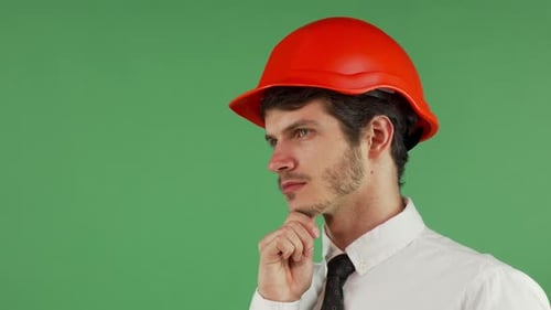 Handsome Male Constructionist in a Hardhat Looking Away Thoughtfully