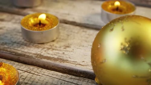 Gold Candles and Christmas Ornaments on Wooden Table
