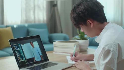 Student Attending Online Lecture and Taking Notes