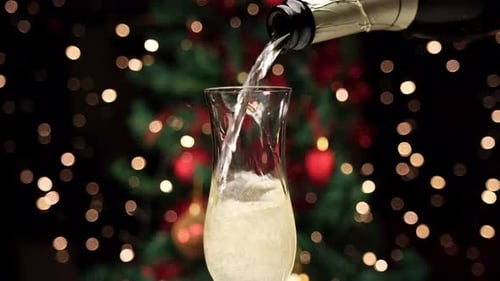 Champagne Poured at Christmas with Bokeh Lights