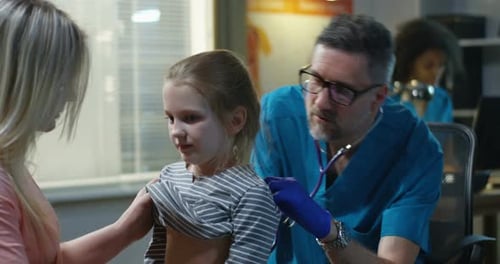 Doctor Examining a Child with Stethoscope in Office