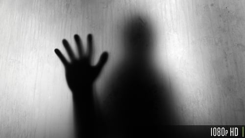 Dark Shadow of a Hand Touching Blurry Opaque Glass and Body Behind it