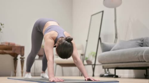 Woman Practicing Yoga Exercises on Mat Indoors
