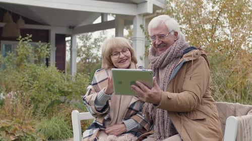 Senior Couple Using Tablet in Their Yard