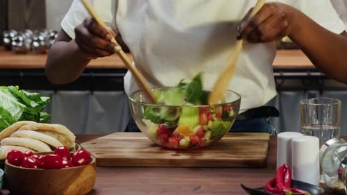 Woman Preparing Colorful Salad in Kitchen