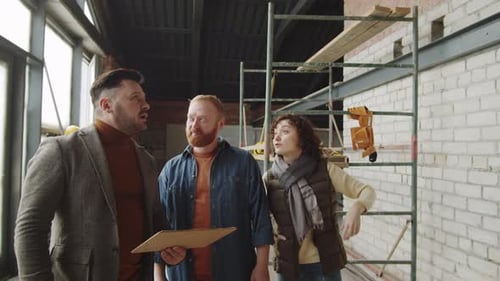 Real Estate Agent Speaking with Couple in Unfinished Apartment