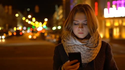 Woman Using Mobile Phone at Night in City
