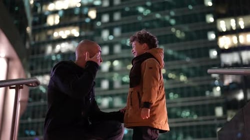 Portrait of a Father and Son in Profile Against the Lights of a Highrise Building