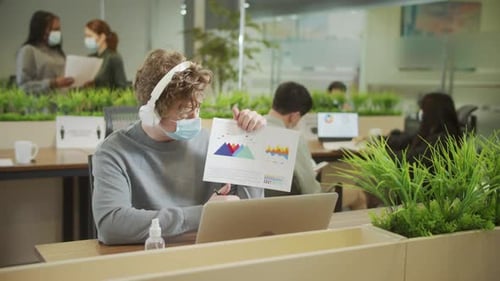 Young Adult Working in Modern Office with Mask