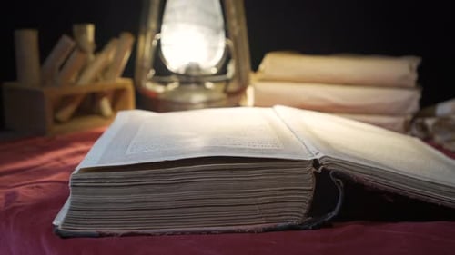 Old Open Book with Scrolls and Lamp