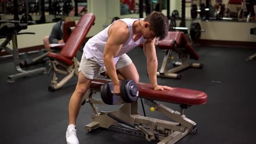 Man Doing Dumbbell Rows on Weight Bench