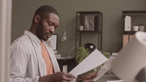 Man Reading Documents in Office Environment