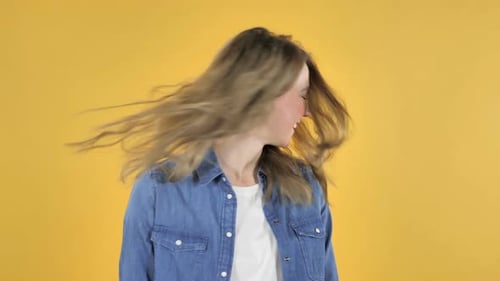 Woman with Blonde Hair Tossing Head on Yellow