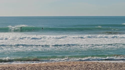 People surfing near the coast of the Atlantic Ocean on a sunny day