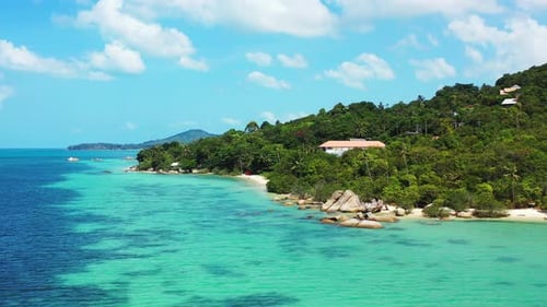 Peaceful seaside of tropical island with blue turquoise sea washing cliffs and exotic beach of shore