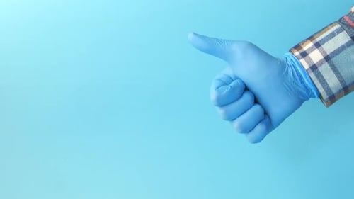 Hand with Glove Giving Thumbs Up on Blue
