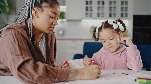 Young Happy African American Mother Drawing Picture with Little Daughter Spending Time Together at
