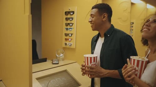 A Couple Buys Tickets at the Ticket Office in a Cinema