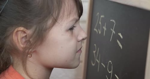 Child Doing Math Problem at Chalkboard Close Up