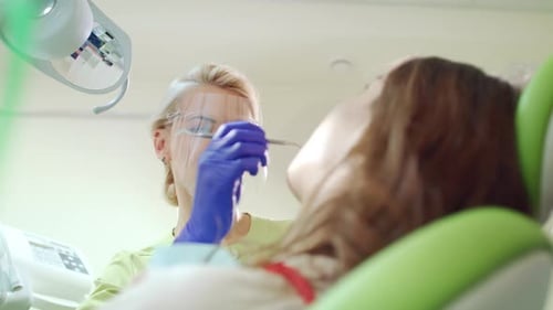 Stomatology Specialist Working with Patient in Dentist Office. Tooth Treatment