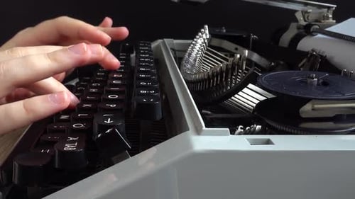 La fille tape sur une machine à écrire rétro.