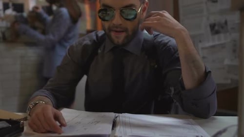 Detective Reviewing Documents in Dimly Lit Office