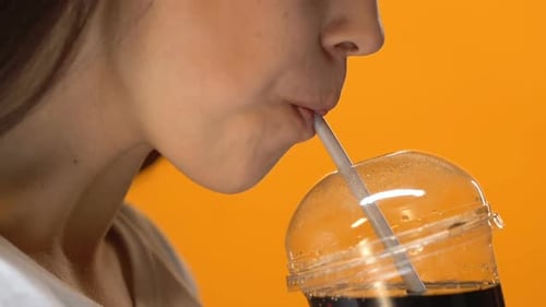 Thirsty Girl Drinking Cold Fizzy Beverage From Plastic Cup With Straw, Close Up