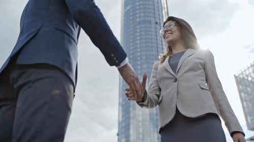 Business Woman and Man Handshake in City