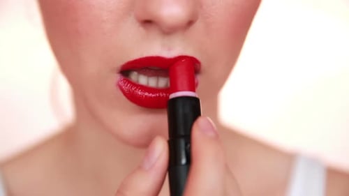 Woman Applies Vibrant Red Lipstick, Close Up