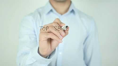 Man Writing Top Secret on Clear Surface