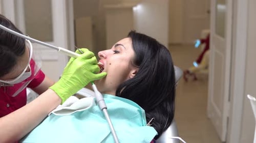 Woman Receives Dental Treatment from Dentist