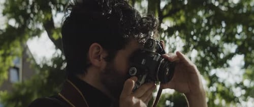 Man Taking Pictures With Vintage Camera Outdoors
