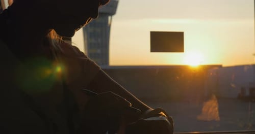 Woman with smart watch in airport at sunset