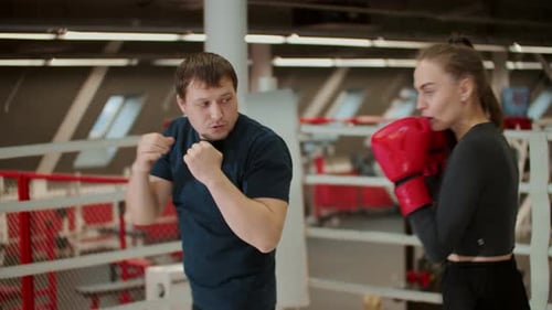 Man and Woman Practicing Boxing in a Ring